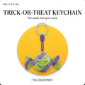 Illustration: the trick-or-treat candy keychain hanging from its cord in front of a yellow circle