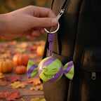 Illustration: a hand holding the trick-or-treat candy keychain clipped to a backpack zipper