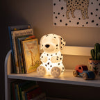 Illustration: the Dalmatian night light glowing at night in a kid's room on a bookshelf beside picture books