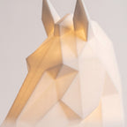 Illustration: close-up of the horse head lamp's faceted face and ears lit from inside