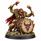 Orc war drummer miniature holding two mallets behind a large hide drum.